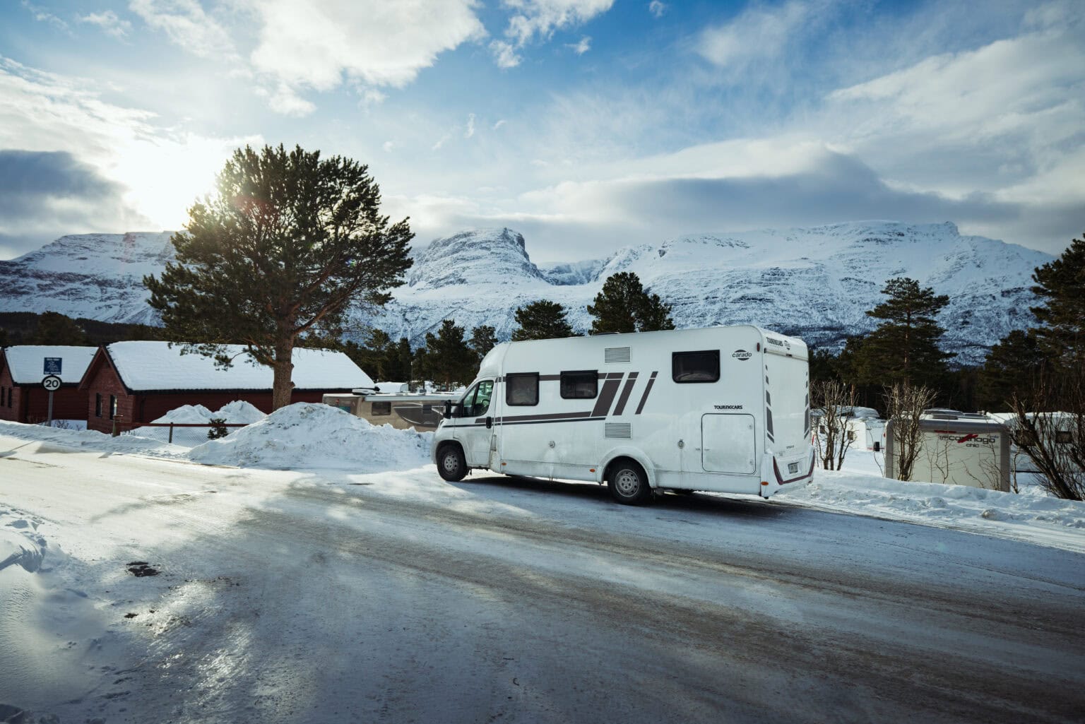 Touring Carsin matkailuauto jäisellä tiellä lumisten tunturien alla Skibotnissa Pohjois-Norjassa