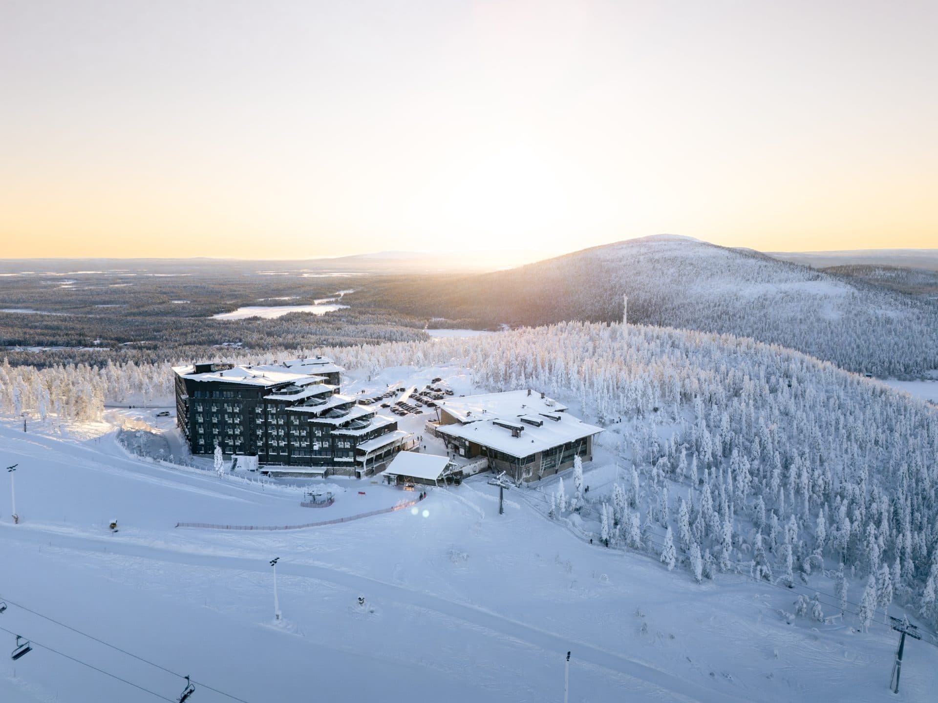 Hotel Levi Panorama ja Levi Summit lumisella rinteellä, matala talviaurinko Levitunturin takana