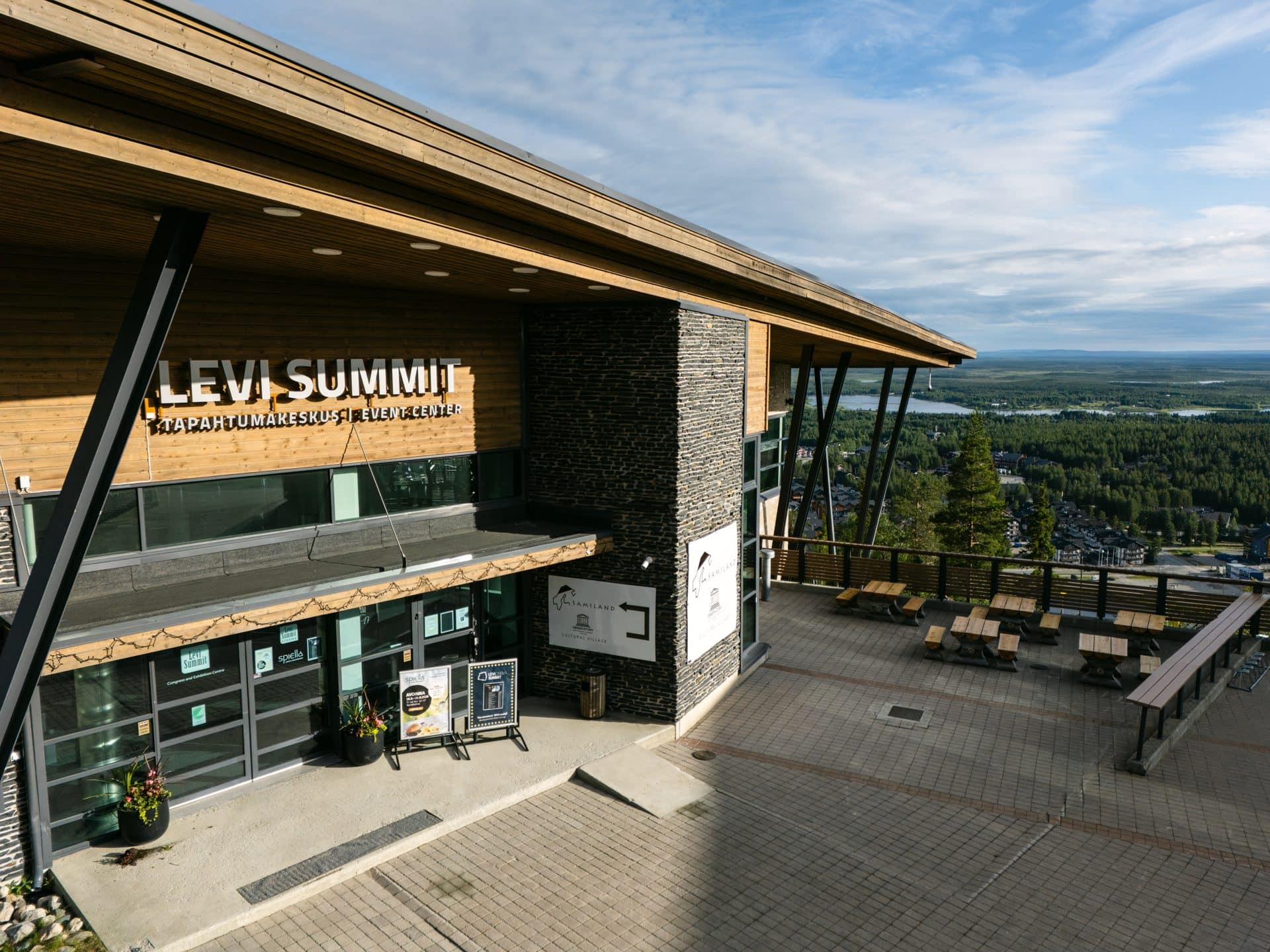 Tapahtumakeskus Levi Summitin sisäänkäynti puisen katoksen alla, terassi ja Levi takana