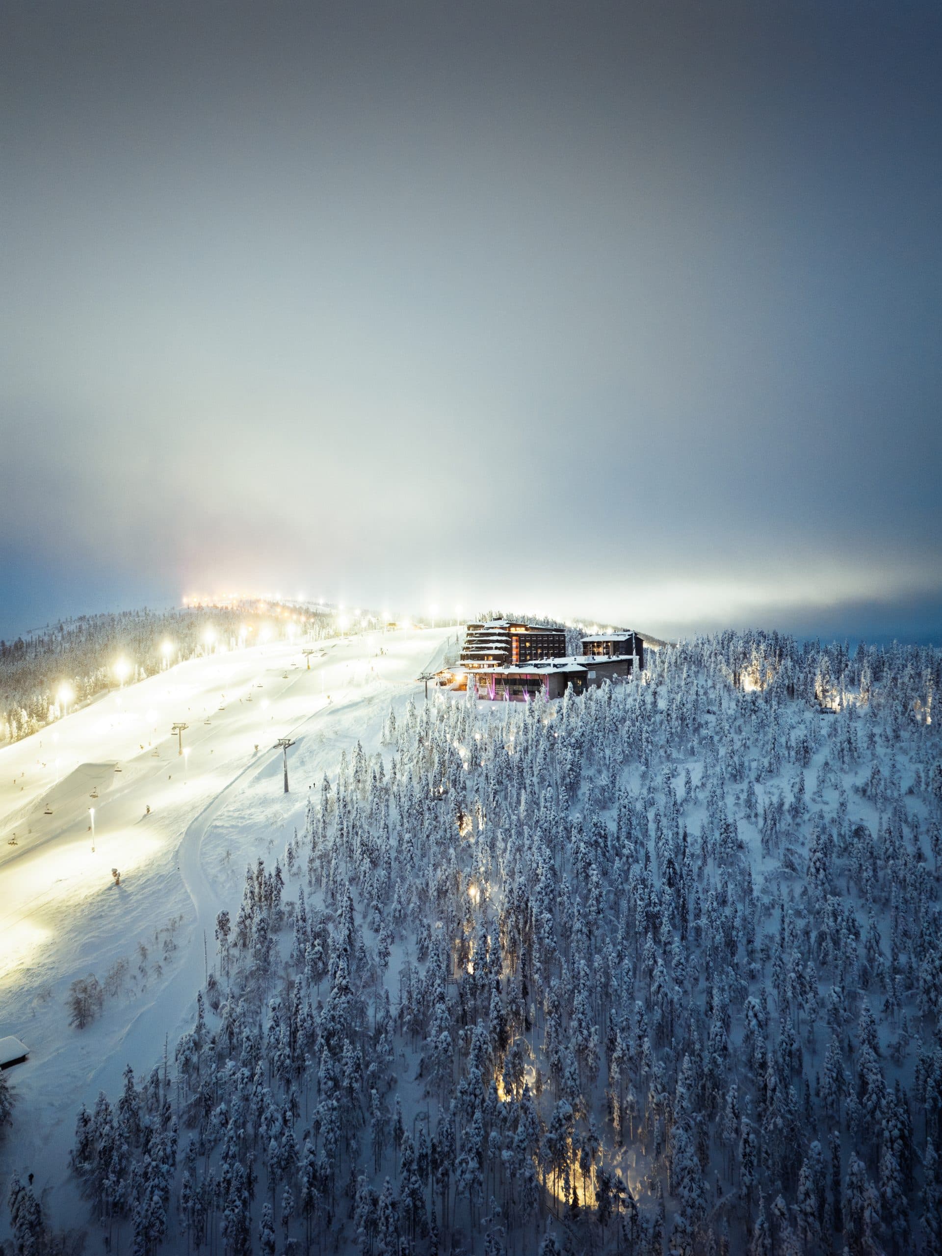 Hotel Levi Panorama ja Levi Summit tunturilla valaistujen rinteiden ja huurteisen metsän yllä yöllä