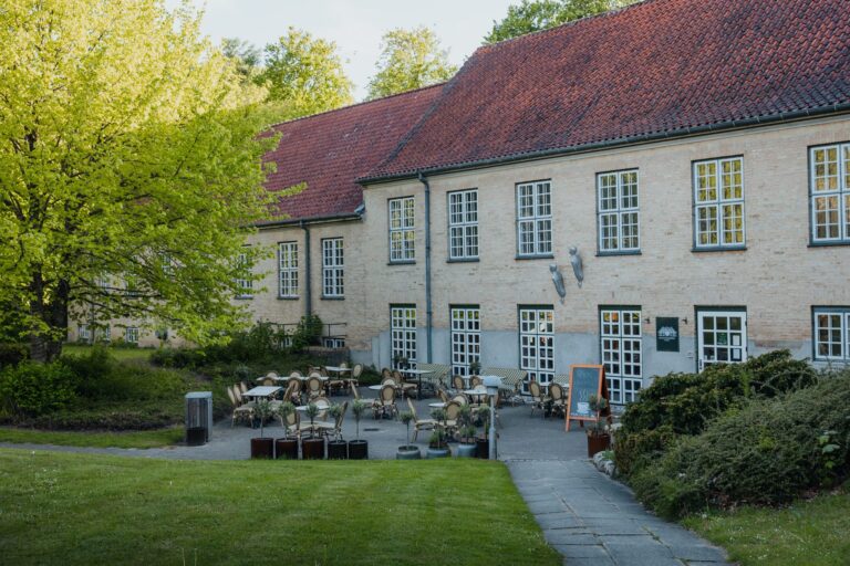 Kahvilan terassi Augustenborg Gardenin tiilirakennuksen edessä kevään puiden alla