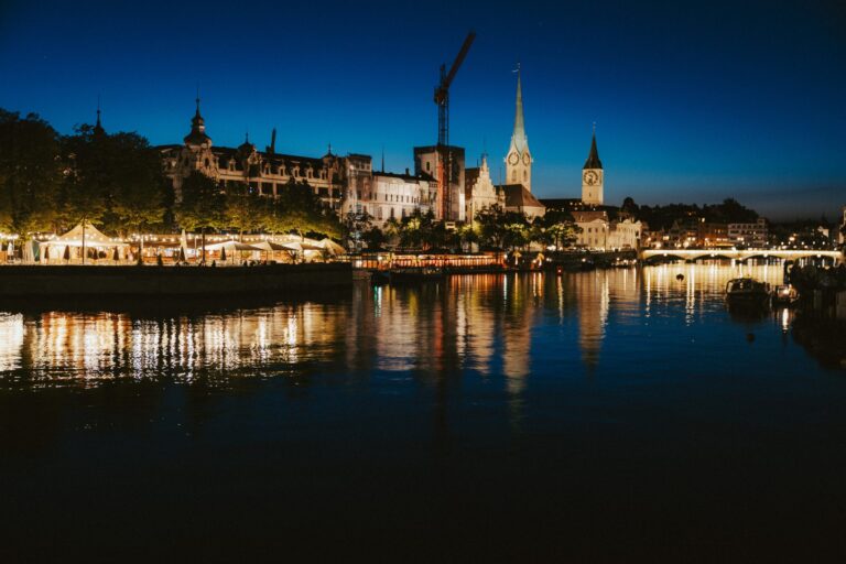 Zürichin vanhakaupunki ja kirkontornit heijastuvat Limmat-jokeen yöllä